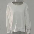 Detail van een wit ruimvallend sweatshirt met verlaagde schoudernaden en geribbelde boorden. - Wit