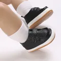 Close-up of black textured baby boy sneakers with soft white and brown soles for infants. - Insole Length 11cm / Black