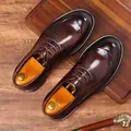 Elegantes zapatos de vestir de cuero marrón oscuro sobre fondo de madera - 38 / Marrón
