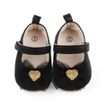 Detail von schwarzen Baby-Prinzessin-Schuhen mit Netzschleife und Goldherz-Applikation. - Schwarz