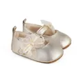 Detalle de zapatos dorados para bebés con lazo de malla y lunares amarillos suaves - Dorado