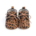 Detailed front view of leopard print baby walking shoes with black textured sides and tan bow - Insole Length 11cm / 2195 Leopard Pattern / Coffee