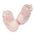 Vue détaillée de chaussons bébé roses en peluche avec bride velcro et tricot - Rose