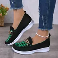 Gros plan de mocassins en maille pour femmes avec motif pied-de-poule et chaîne dorée. - Noir