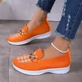 Vue détaillée des mocassins à plateforme en maille orange avec chaîne dorée et motif. - Orange
