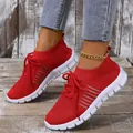 Detailed shot of red breathable fly-knit mesh sneakers featuring thick white textured soles. - Red