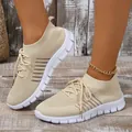 Detailed close-up of women's beige breathable fly-knit sneakers with white flexible soles. - 36 / Off White
