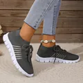 A detailed side view of breathable dark grey mesh knit sneakers worn by a model - 36 / Dark Gray