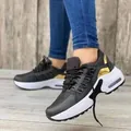 Close-up of women's black wedge sneakers with gold accents and chunky sole - 35 / Black
