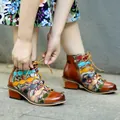 Detailed view of handmade genuine leather vintage patchwork ankle boots being tied - 36 / Brown