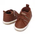Detaillierte Nahaufnahme brauner Neugeborenen-Sneaker mit weicher Sohle und Klettverschluss. - Braun