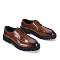 Close-up detail of glossy brown leather derby shoes featuring a stylish thick lug sole - Tan