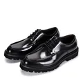 Detailed view of glossy black patent leather shoes with thick lug soles for men's business wear - Black