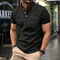 Detailed view of black men's polo shirt with chest pocket and white button closure - Black