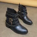 Detailed side view of black Martin boots featuring silver studs and multiple buckle straps. - 36 / Black