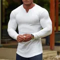 Dettaglio della maglietta a compressione bianca a maniche lunghe a coste da uomo fitness - Bianco