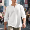 Detail view of men's white waffle knit long sleeve Henley shirt in street setting - M / Tops / White