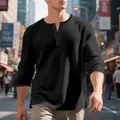Detailed macro view of the black waffle knit texture on a men's long sleeve Henley shirt - M / Tops / Black