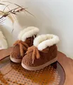 Detailaufnahme von warmen braunen Baby-Schneestiefeln mit weißem Fellbesatz - Braun