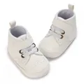 Close-up view of white soft-sole baby boots featuring brogue detailing and velcro strap - Inner Length 11cm / White