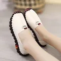 Detail view of comfortable white genuine leather flat shoes for women on feet - White