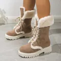 Close-up of brown suede snow boots with white faux fur trim and lace-up details - 36 / Camel