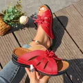 Detailweergave van rode sleehaksandalen met uitsnijdingen, strik en witte stiksels - Rood