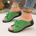 Nahaufnahme von grünen Peep-Toe-Hausschuhen mit Hohlmuster und süßer Schleife und Sohle - Grün