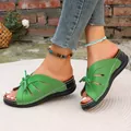 Detail van groene peeptoe-sandalen met een uitgesneden ontwerp en strik op sleehak - Groen