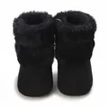 Detailed view of black fuzzy infant winter boots featuring soft sole and bow accent - Black