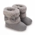 Close-up view of grey baby winter boots with faux fur trim and cute bow detail. - Gray