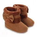 Détail rapproché de bottes d'hiver marron pour bébé avec bordure en peluche et petits nœuds - Marron