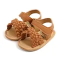 Detail van bruine gevlochten baby sandalen met zachte zool en klittenbandsluiting. - 11cm / Tan