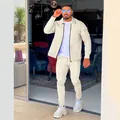 Full-body view of a man wearing a beige waffle-knit jacket and matching jogger set. - S / Top And Bottom / Khaki