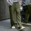 Detail of men's olive green pleated wide-leg trousers with ribbed texture and drawstrings. - S / Bottoms / Army Green