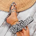 Trendy leopard print open-toe square toe flat sandals for women on a rustic wood floor - Beige