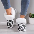 Close-up detail of stylish cow print women's winter snow boots with soft white faux fur lining - 36 / Cow Print (White)