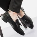 Nahaufnahme von eleganten schwarz geflochtenen Leder-Loafers mit Quasten für Herren. - 38 / Schwarz