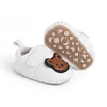 Detail von weichen weißen Babyschuhen mit Bärenmotiv und rutschfester Gummisohle - Weiß