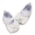 Close-up of elegant white lace bow on baby girl soft sole princess walker shoes. - White