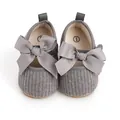 Detailansicht grauer Strick-Babyschuhe für Mädchen mit einer großen Zierschleife - 11cm / Grau