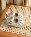 Gros plan de chaussures Mary Jane pour bébé beige avec bout plissé et cuir souple - Beige