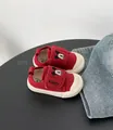 Dettaglio di scarpe di tela rosse per neonati con ricamo Mickey Mouse e suola bianca morbida - Borgogna