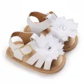 Primer plano de sandalias blancas para bebé niña con flores grandes de tela y hebillas doradas - Dorado