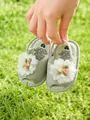 Gros plan de sandales vertes pour bébé avec dentelle florale et boutons de rose - Fleur verte