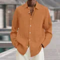 Detail view of men's orange ribbed long-sleeve casual shirt with lapel and white buttons. - S / Tops / Orange