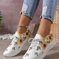 Modische weiße Sneaker mit dicker Sohle sowie lebhaften Sonnenblumen- und Schmetterlings-Prints. - Grün
