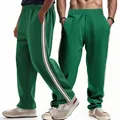 Close-up detail of green men's joggers with stylish beige side stripes and loose fit. - S / Bottoms / Green