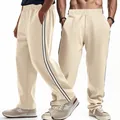 Detailed close-up view of men's cream joggers featuring black side stripes and loose fit - S / Bottoms / Apricot