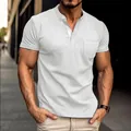 Close-up view of a white men's short-sleeved henley shirt featuring a chest pocket detail - White